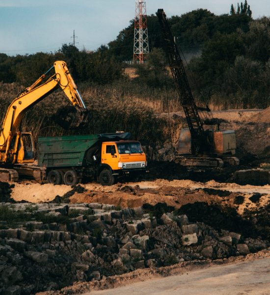 A closeup shot of an ongoing construction  with tracks and a bulldozer on an  abandoned land